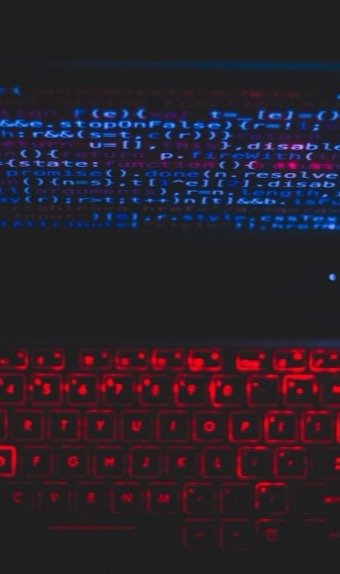Laptop med kode i mørkt miljø